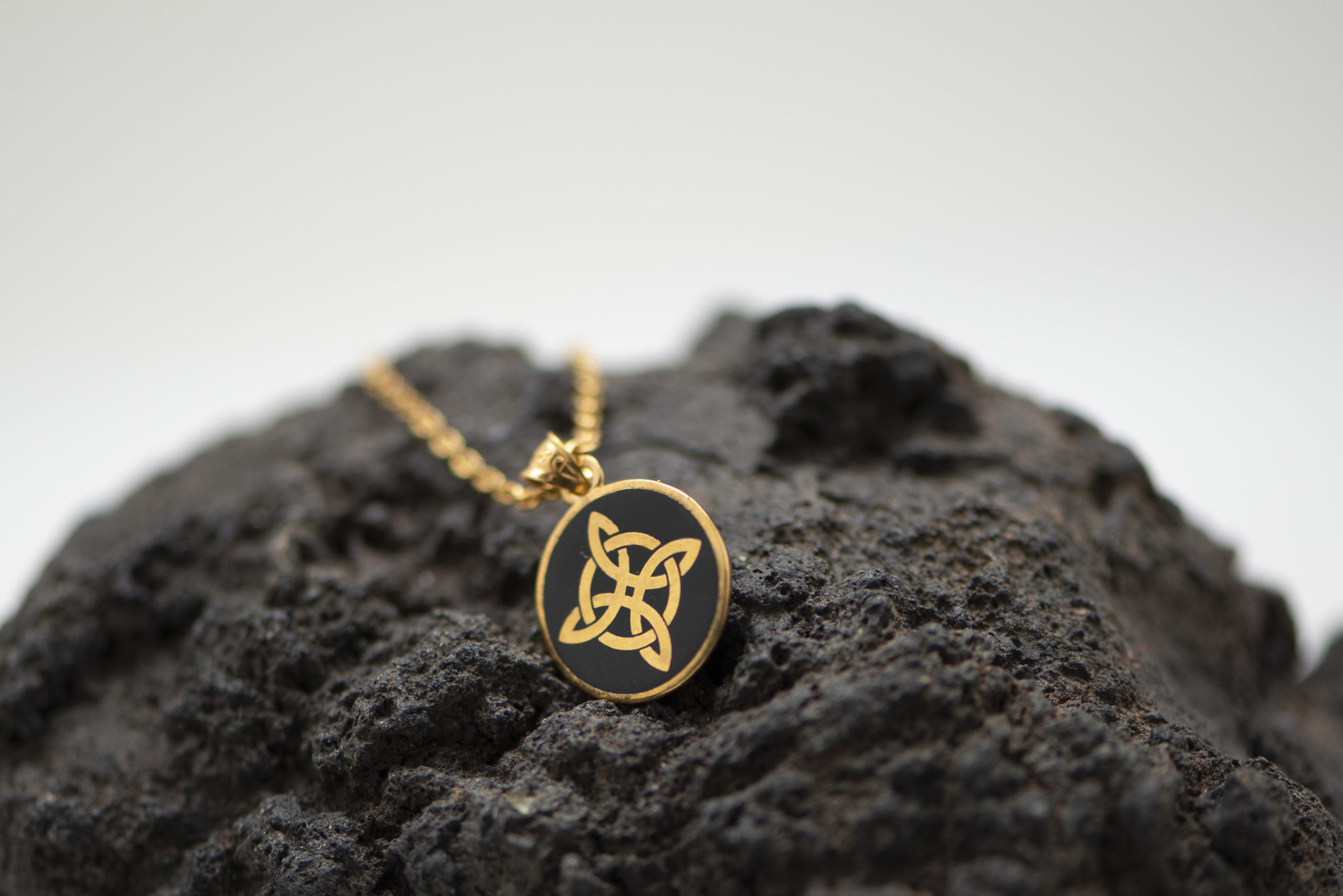 Descubre nuestro Colgante Nudo de Bruja en chapado oro 18k con esmalte negro artesanal. Talismán protector. 13 mm. Cadena incluida. Envío gratis.