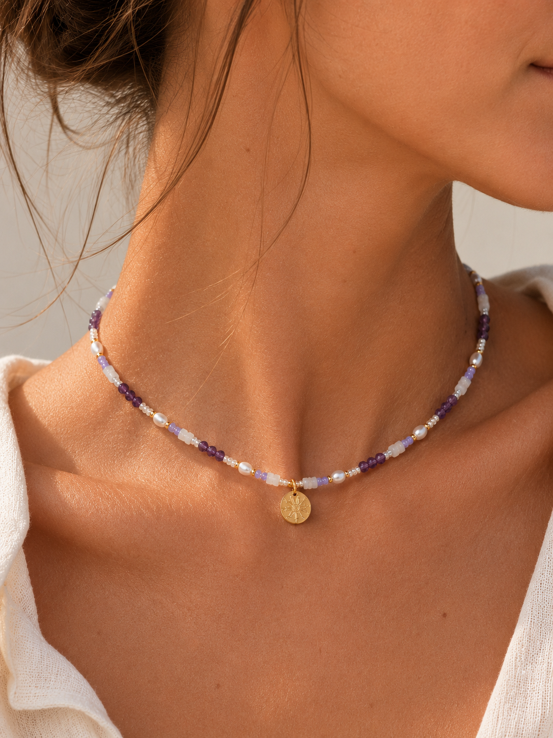Collar Eguzkilore en acero dorado con piedras violeta y perlas nacaradas